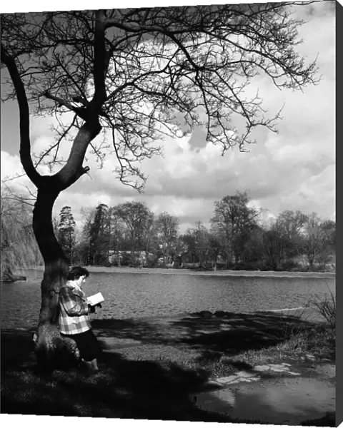 Woman reading her book by the lake in the park at St. Albans. March 1952 C1266-003
