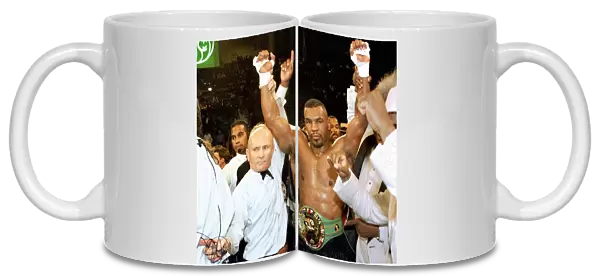Mike Tyson has his arms raised by referee Mills Lane after beating Frank Bruno for