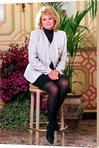 ANGIE DICKINSON WEARING JACKET AND SKIRT SITTING ON STOOL AT PHOTOCALL - 14  /  10  /  1993