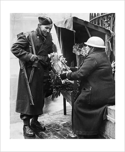 A British soldier buying flowers for his wife in central London as he returns home