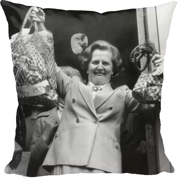 MARGARET THATCHER HOLDS ALOFT BAGS WITH SHOPPING BOUGHT IN 1974 AND 1979 TO ILLUSTRATE