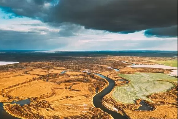 Europe. Aerial View Of Dry Grass And Partly Frozen Curved River Landscape In Autumn Day. High Attitude View. Marsh Bog. Drone View. Bird's Eye View