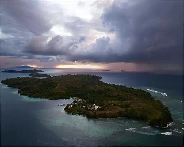 Storm clouds dump rain near a remote tropical island in the Solomon Islands. This beautiful country is home to spectacular marine biodiversity