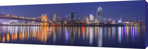 Cincinnati, Ohio, USA downtown skyline and bridge on the river at dusk