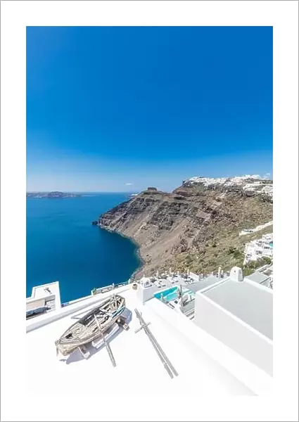 Scenic view of traditional cycladic resort with decoration boat foreground, Oia village, Santorini, Greece. Famous travel destination, luxury holiday