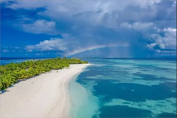 Sky and sea with aerial island landscape rainbow. Fantastic aerial landscape in Maldives islands, stormy clouds with rainbow and amazing sea view