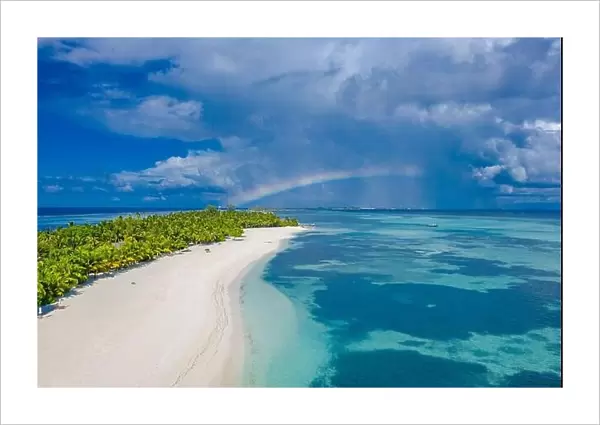 Sky and sea with aerial island landscape rainbow. Fantastic aerial landscape in Maldives islands, stormy clouds with rainbow and amazing sea view