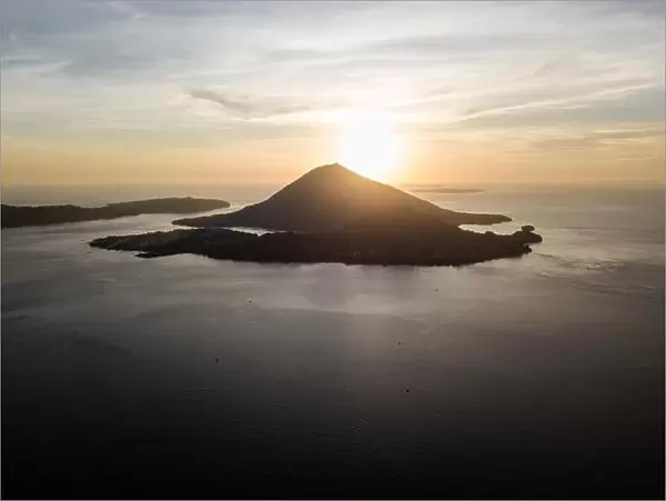 The sun sets behind Banda Neira, an active volcano in the Banda Sea. This region is in the Coral Triangle and has high marine biodiversity
