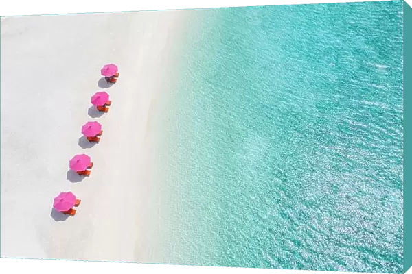 Aerial view of umbrellas, lagoon with sandy beach of Indian Ocean at summer holiday. Tropical landscape with sunny tropical coast shore. Amazing beach