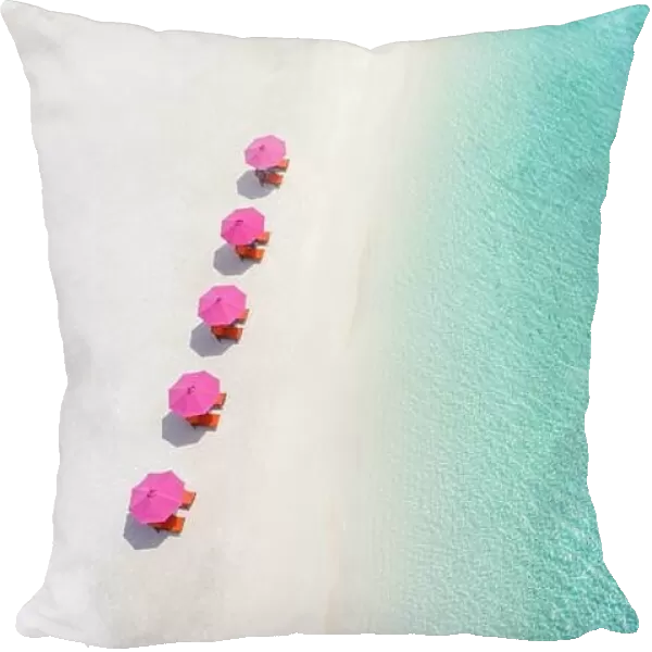Aerial view of umbrellas, lagoon with sandy beach of Indian Ocean at summer holiday. Tropical landscape with sunny tropical coast shore. Amazing beach