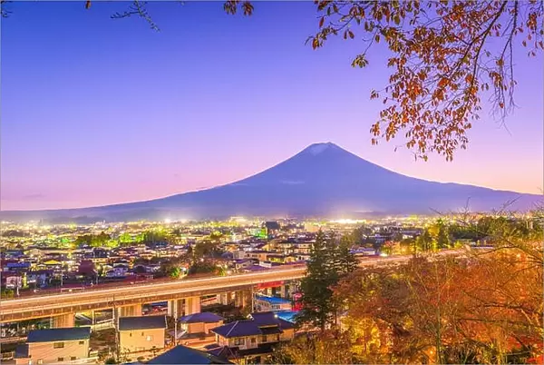 Fujiyoshida, Japan town skyline below Mt. Fuji at twilight during autumn season