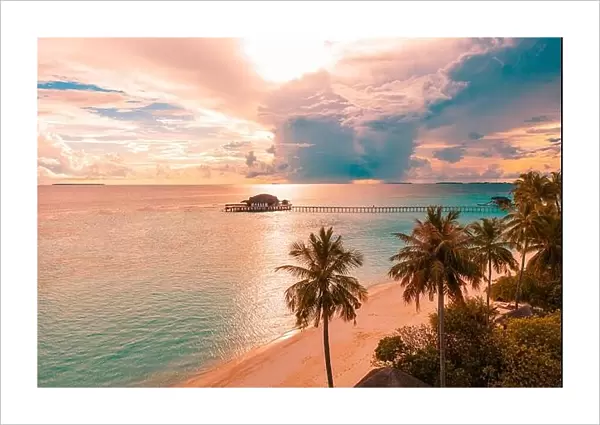Aerial sunrise sunset beach bay view, colorful sky and clouds, wooden jetty over water bungalow. Meditation relaxation tropical drone view, sea ocean