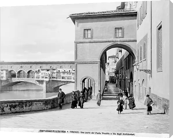 View with people of Lungarno degli Archibusieri and part of the Vasari Corridor. Ponte Vecchio is in the background
