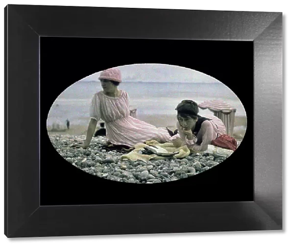 Two women sitting on a beach