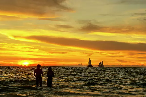 Florida, Clearwater, sailing ship on the horizon with golden sky
