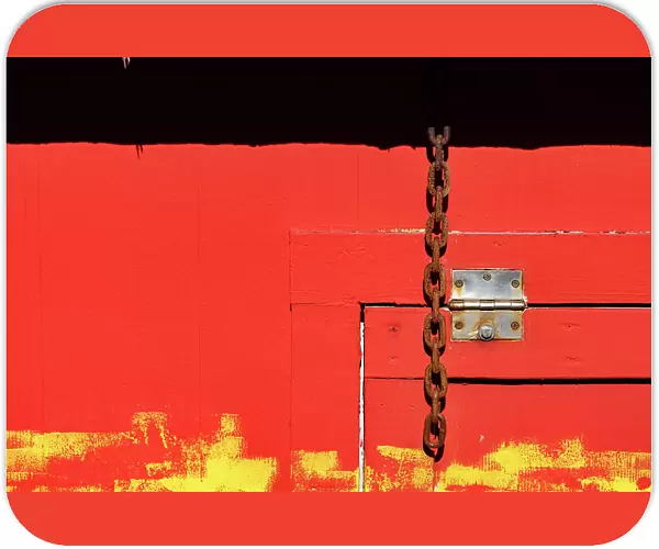 Red wooden structure with door hinge and chain