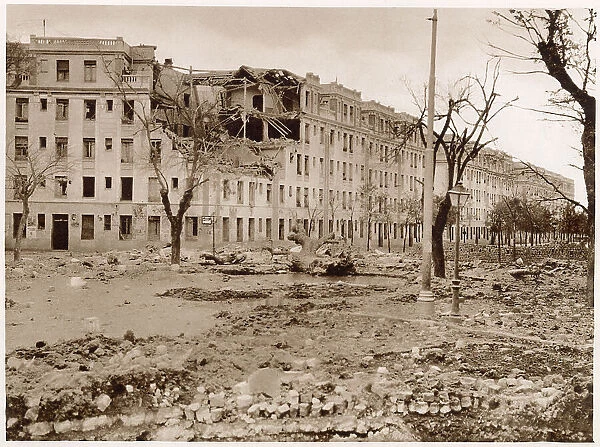 An avenue in the West of Madrid after bombardment by the Nationalist airforce and artillery, November 1936. A barricade made of cobbles and bricks can be seen on the right of the photograph