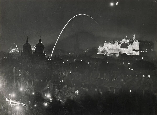 Edinburgh Castle floodlit during the Tattoo, when signalling maroons and rocket were fired. The twin towers of Stewart's College and dome of the Bank of Scotland on left. Date: 1960s