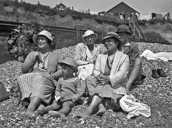 Family group on a pebbly beach at the seaside