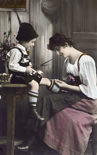 German Bavarian Mother mends her young sons sock
