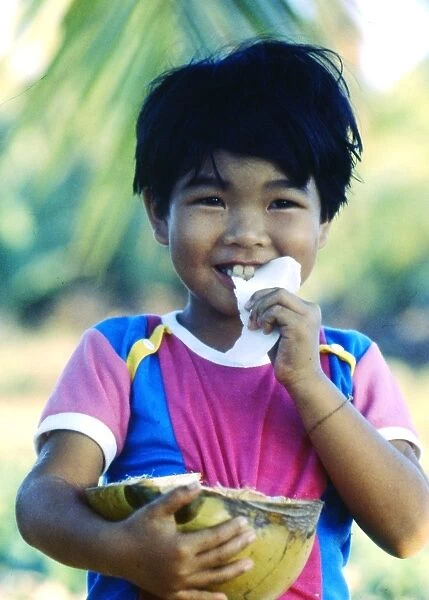 Little boy eating coconut, Thailand