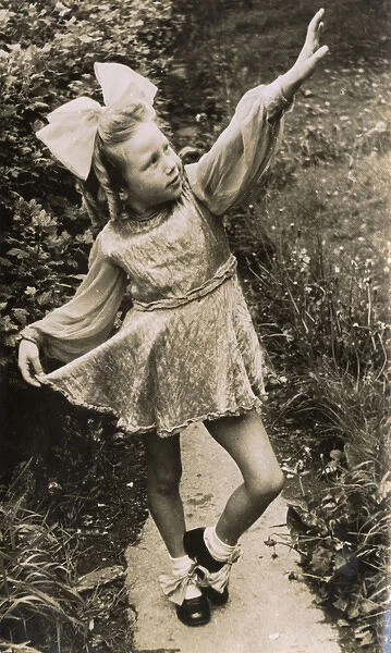 Little girl in costume, posing on a garden path