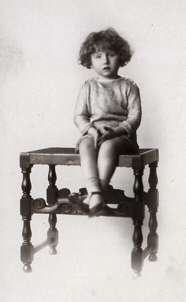 A Little girl photographed on a turned wooden stool