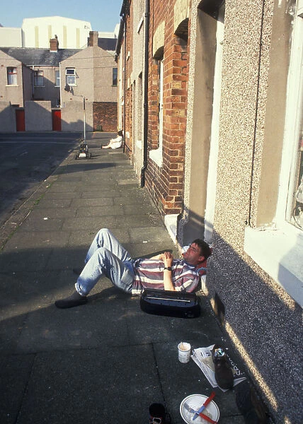 Man snoozing outside his house in Stewart Street, Barrow in