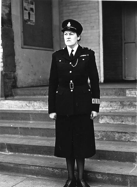 Woman police officer outside police station, London
