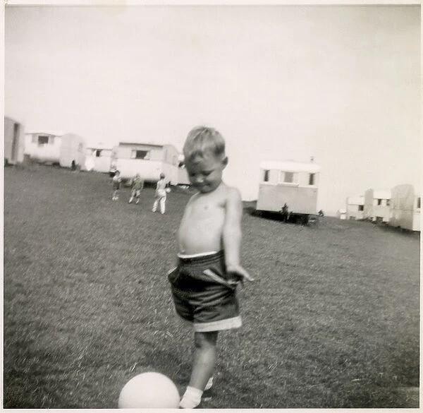 Young boy plays with a football at a holiday camp
