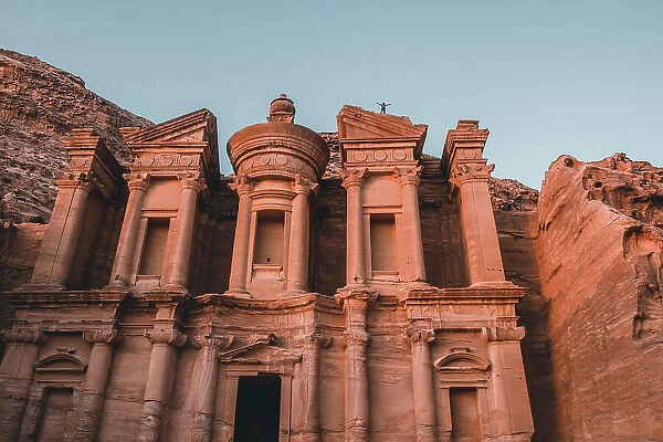 Al Deir (Monastery) facade at sunset with some people on top of it, Petra, UNESCO World Heritage Site, Jordan, Middle East