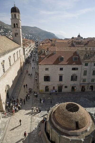 The Big Fountain of Onofro and view along Stradun Street, tower of the Church of St
