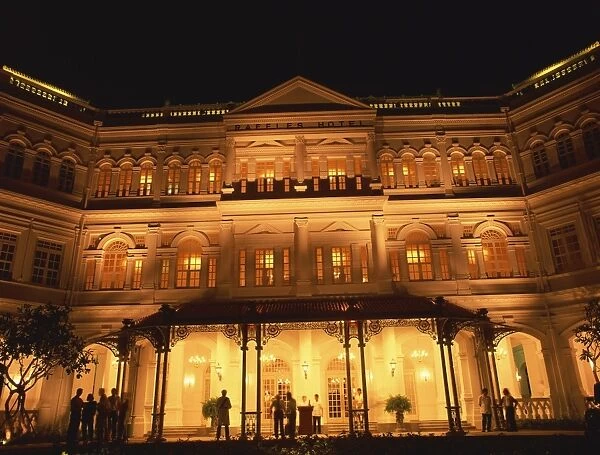 The facade of the Raffles Hotel at night in Singapore