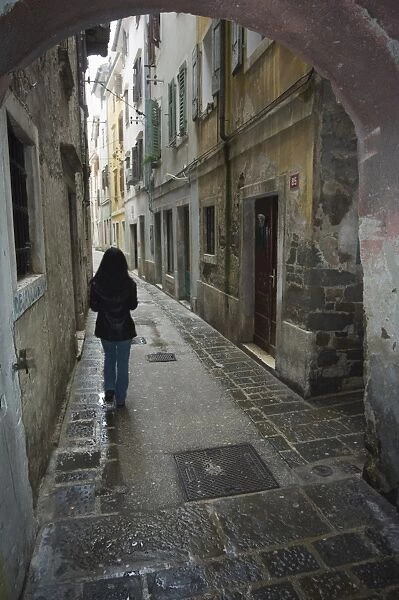 Girl walking through old street