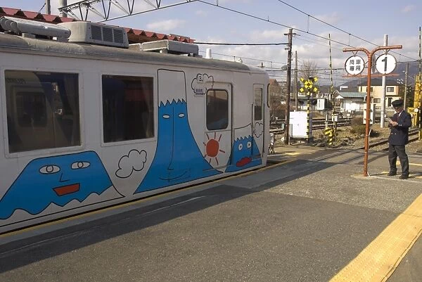 Local train at station platform with fun drawings of Mount Fuji