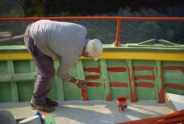 Man painting the inside of a boat on Malta