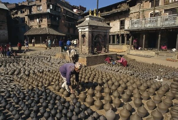Man with rows of clay pots drying in Potters Square