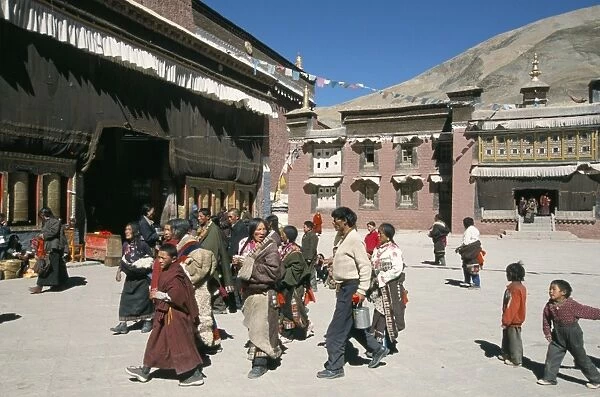 Pilgrims in monastery courtyard, . Sakya, Tibet, China, Asia
