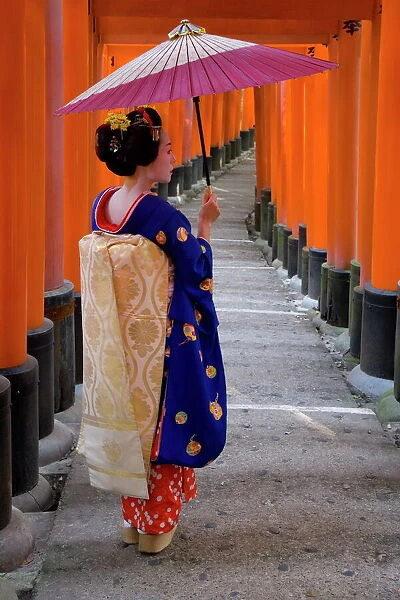 Portrait of a geisha holding an ornate umbrella at