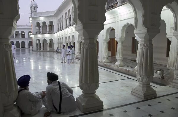 Two Sikhs priests at dawn sitting under arcades