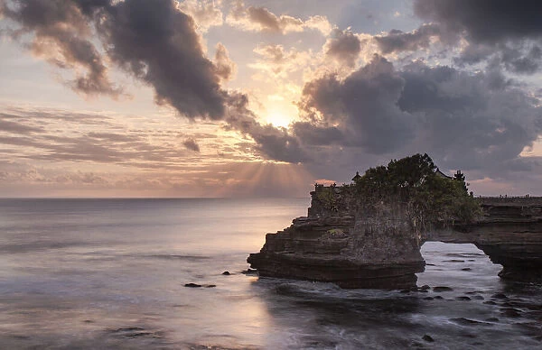 Sunset on Batu Bolong temple on a natural arch in the sea, Bali, Indonesia