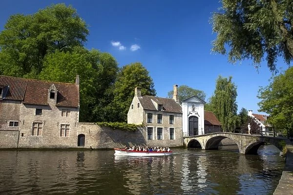 Tourist boat, at the Minnewater Lake and Begijnhof Bridge with entrance to Beguinage