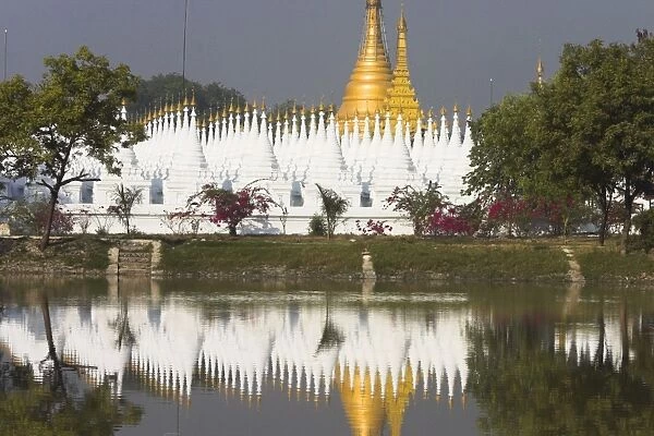 White stupas of Sandamani Paya reflecting in moat, Mandalay, Myanmar (Burma), Asia