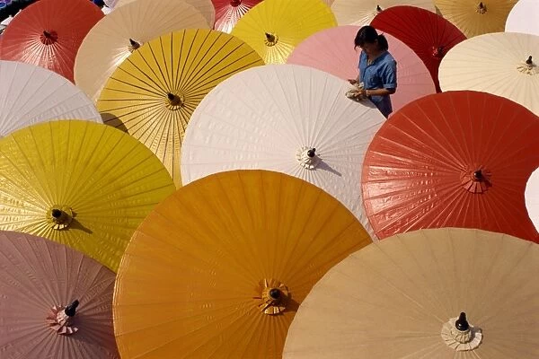 Woman finishing painted umbrellas in a village near Chiang Mai