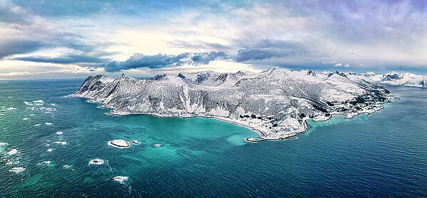 Aerial panoramic view of Bovaer beach and majestic cliffs in the crystal cold sea, Skaland, Senja, Troms county, Norway