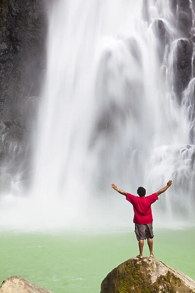 Dominica, Delices. A man stands at the base of Victoria Falls, one of the tallest