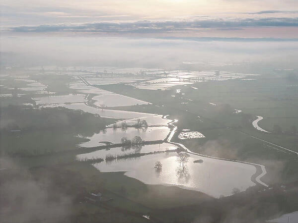 Flooded fields on the Somerset Levels on a misty morning, Glastonbury, Somerset, England. Winter (December) 2023
