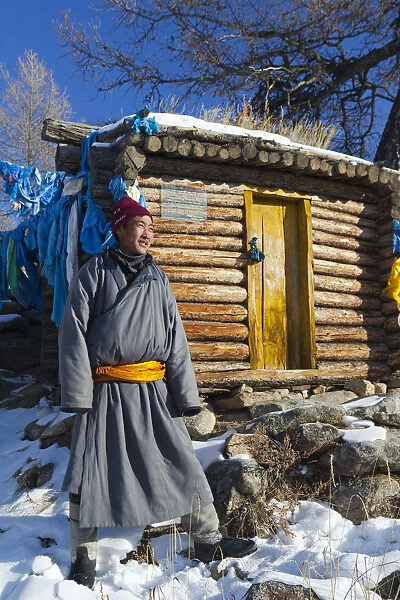 Mongolia, Ovorkhangai, Orkhon Valley. A Mongolian man stands by a hut at hot springs
