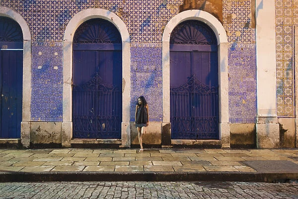 South America, Brazil, Maranhao, Sao Luis, a girl stops for a rest in a colonial street