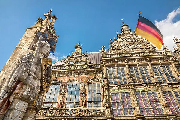 Statue of Bremen Roland in front of the town hall with the German flag on the market square, Bremen, Germany